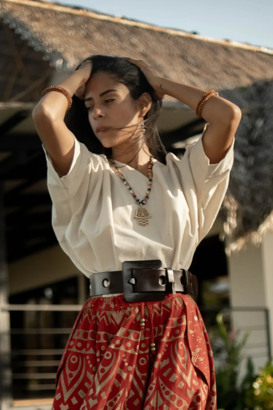 Woman wearing the Sira leather belt over a printed skirt with a cream blouse